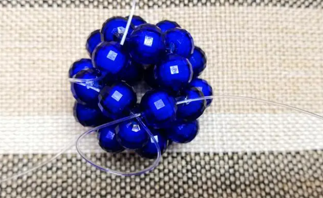 第十四步：右手線穿上兩顆珠子，并回穿與左線打結(jié)，形成如圖15的樣子