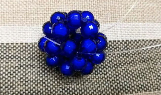 第十四步：右手線穿上兩顆珠子，并回穿與左線打結(jié)，形成如圖15的樣子