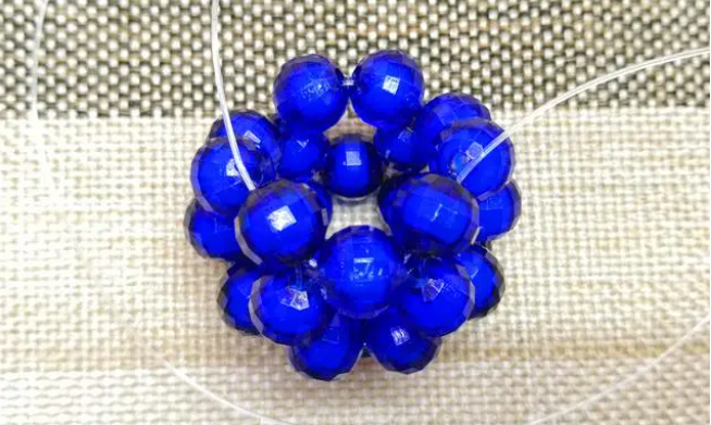 第十四步：右手線穿上兩顆珠子，并回穿與左線打結(jié)，形成如圖15的樣子